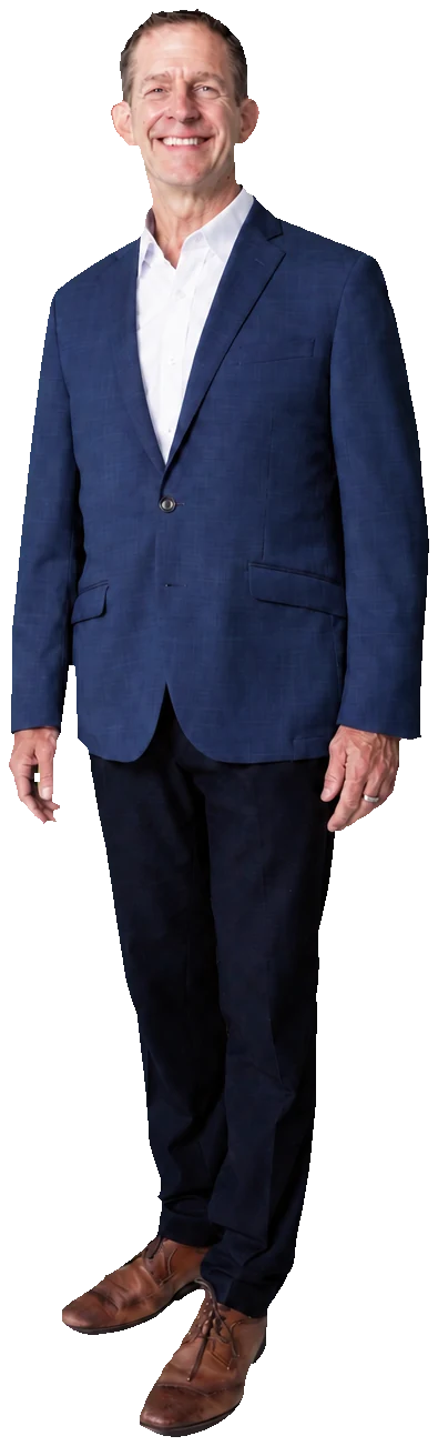 Rick Janson standing in a navy blazer and relaxed dark trousers